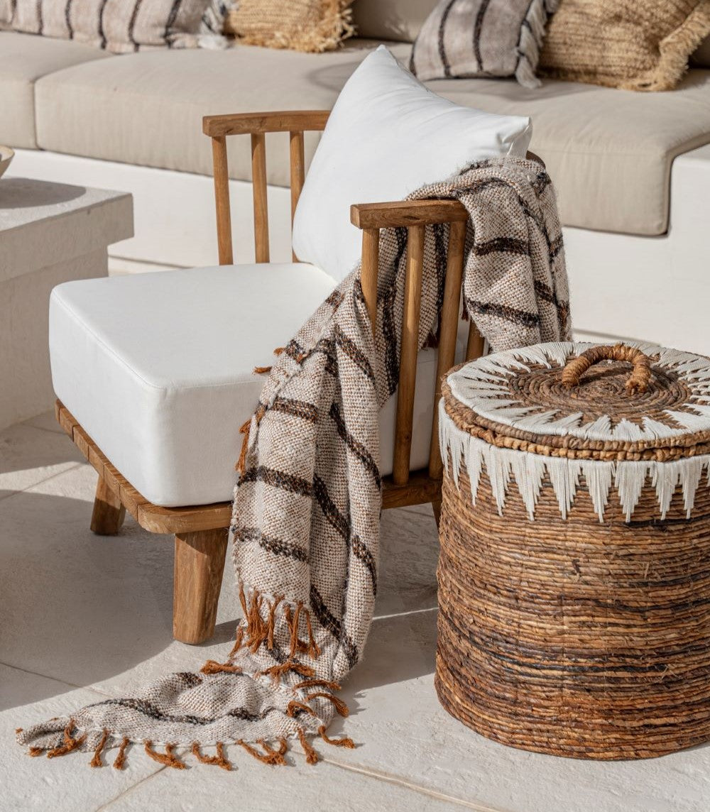 Plaid blanc bohème rayé noir sur fauteuil extérieur