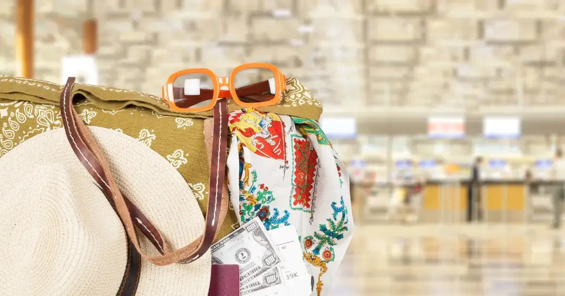 Sac de voyage posé dans un hall d'aéroport avec lunettes de soleil et chapeau, prêt pour le départ en avion