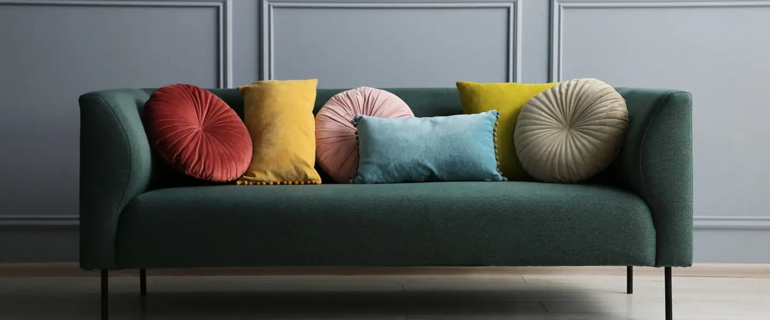Canapé vert design décoré de coussins colorés de différentes tailles et formes - inspiration déco pour choisir la taille idéale de housses de coussin