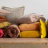 Coussins en promotion posés empilés sur une table plusieurs coloris