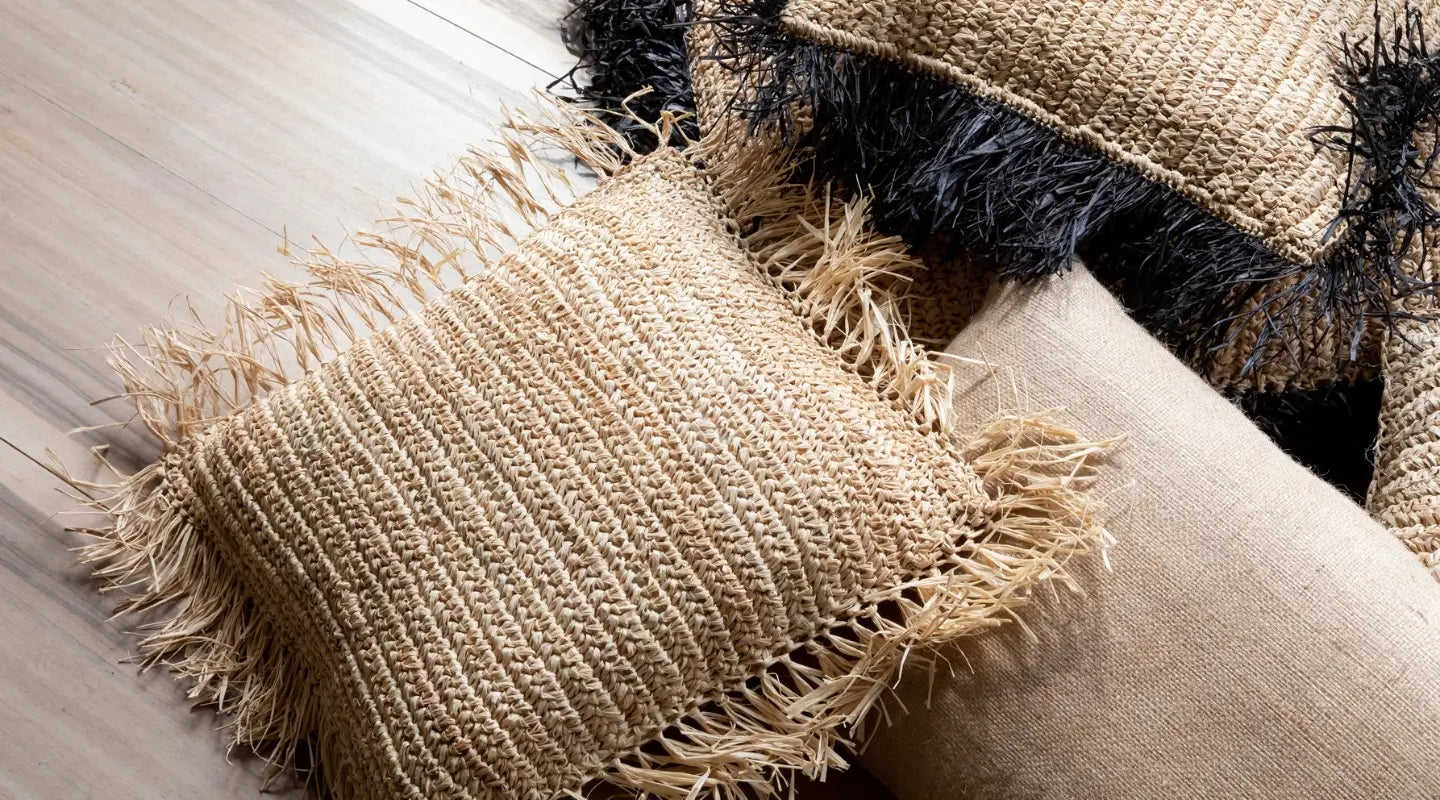 Housses de coussin bohèmes en promotion posés sur un parquet