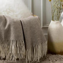 Plaid en laine en promotion dans un panier, avec coussin déco et vases bohèmes