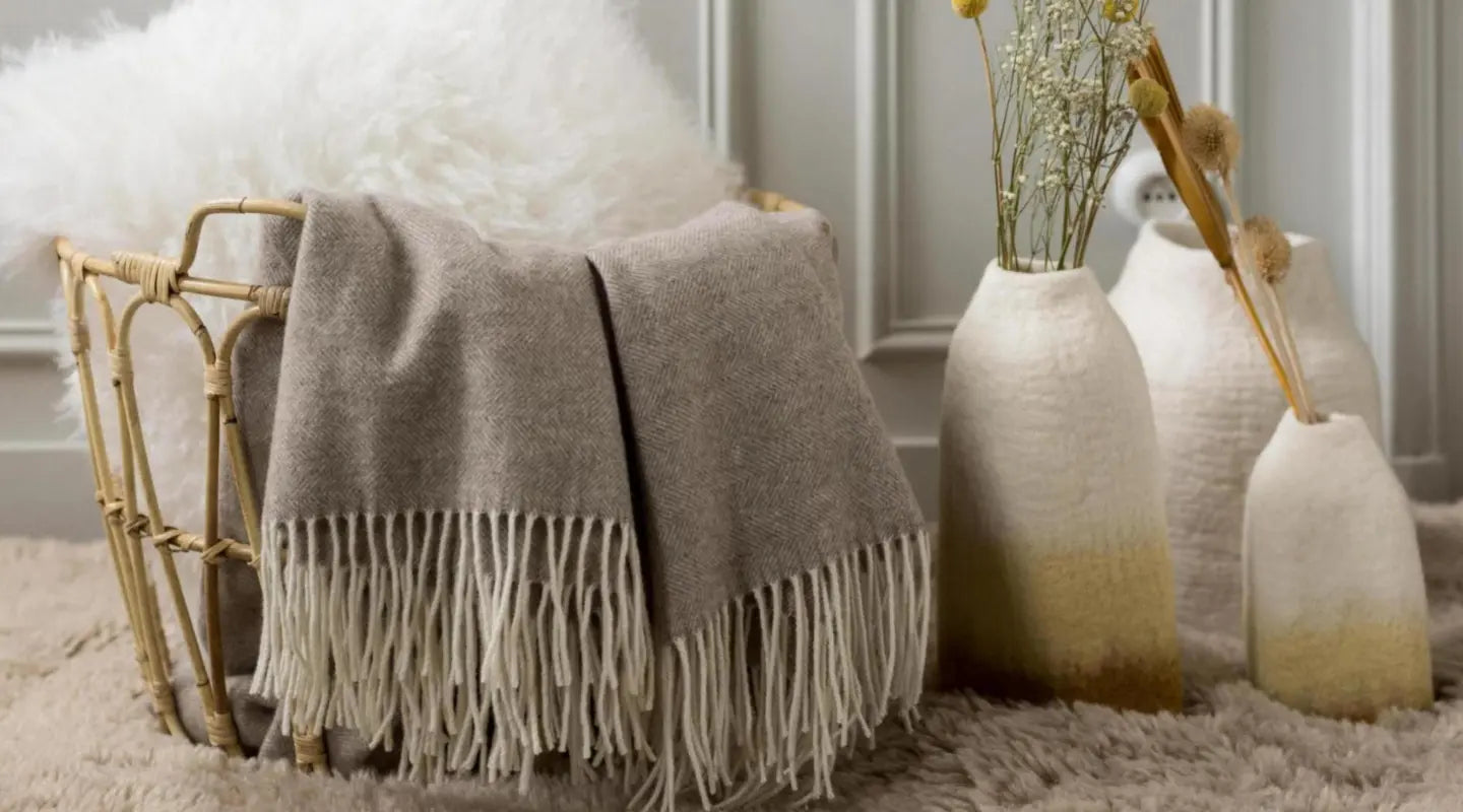 Plaid en laine en promotion dans un panier, avec coussin déco et vases bohèmes