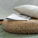 Pouf en osier posé sur un tapis dans une chambre