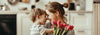 Geste d'amour entre une mère et son enfant pour la Fête des mère, bouquet de tulipes à la main