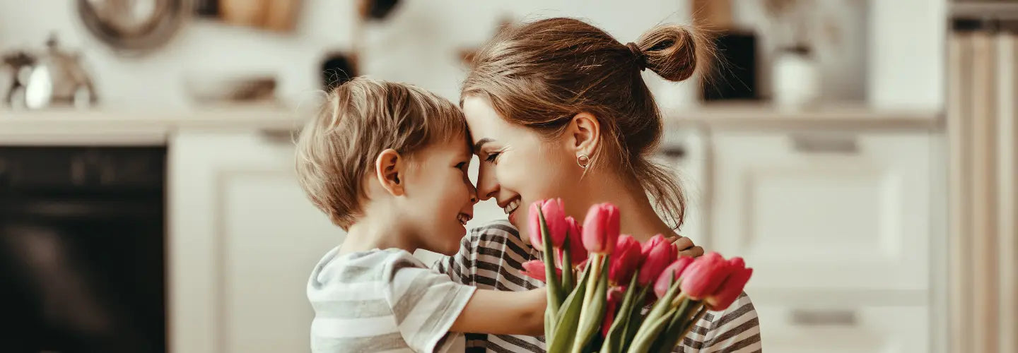Geste d'amour entre une mère et son enfant pour la Fête des mère, bouquet de tulipes à la main